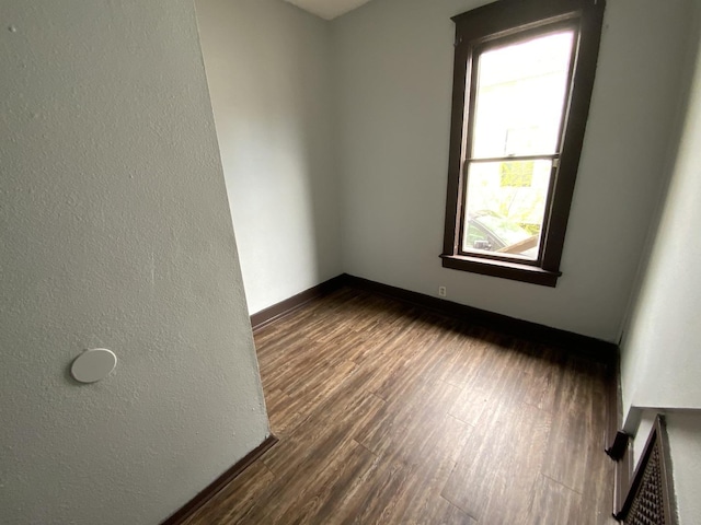 empty room with dark hardwood / wood-style flooring