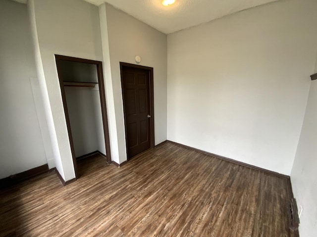 unfurnished bedroom featuring dark hardwood / wood-style flooring and a closet