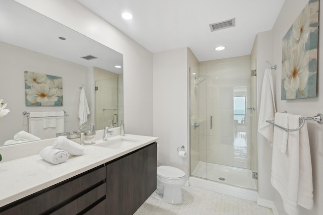 bathroom featuring a shower with door, vanity, tile patterned floors, and toilet