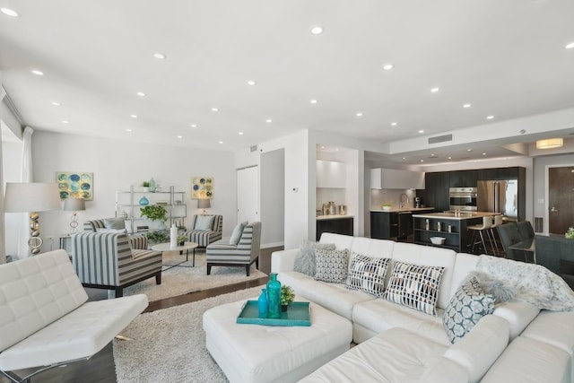 living room featuring sink and light hardwood / wood-style flooring