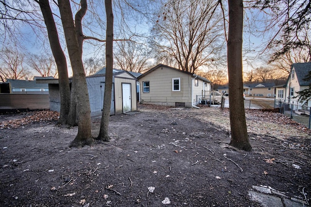 back house at dusk with an outdoor structure