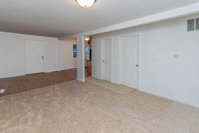 basement featuring carpet flooring and a textured ceiling