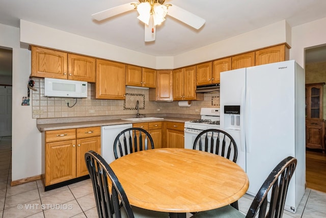 kitchen featuring tasteful backsplash, white appliances, sink, and light tile patterned floors