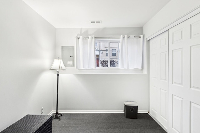 unfurnished bedroom featuring dark colored carpet, electric panel, and a closet