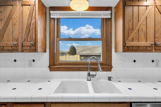 kitchen featuring sink, decorative backsplash, and tile countertops