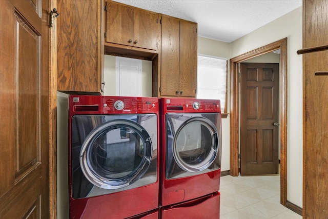 laundry area with cabinets, a textured ceiling, and independent washer and dryer