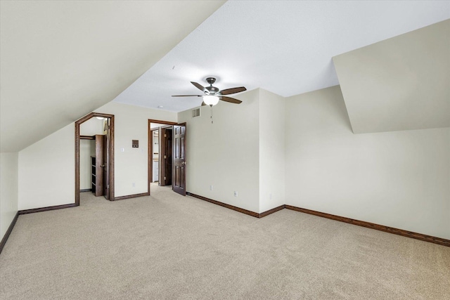 additional living space featuring ceiling fan, light colored carpet, and lofted ceiling