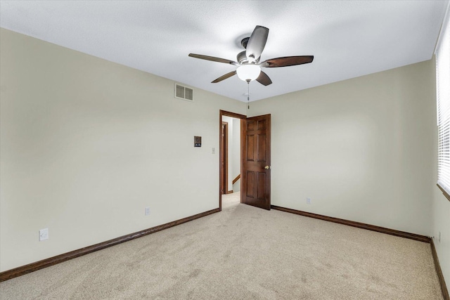 empty room featuring light colored carpet and ceiling fan