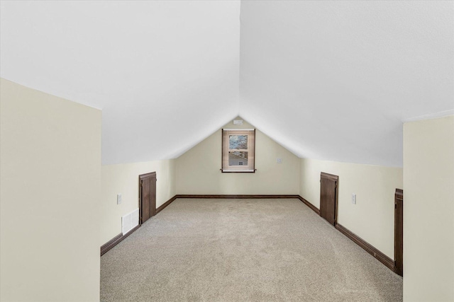 bonus room featuring vaulted ceiling and light carpet