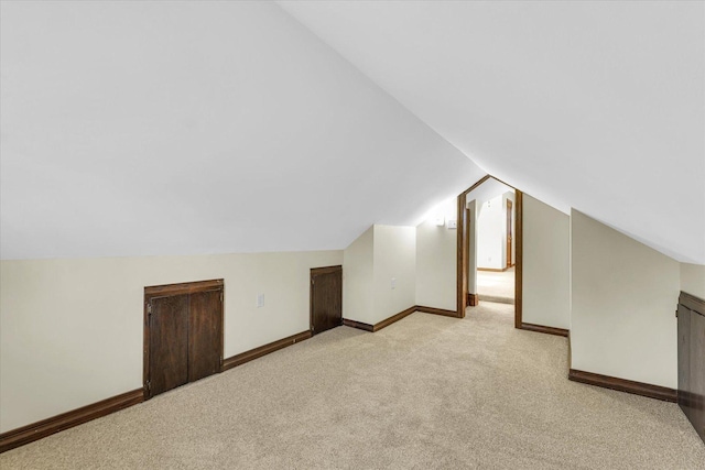 bonus room featuring light carpet and vaulted ceiling