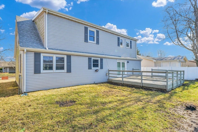 back of property with a wooden deck and a yard