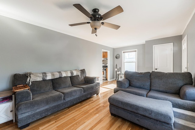 living room featuring hardwood / wood-style floors, crown molding, and ceiling fan