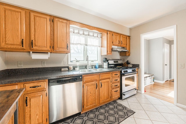 kitchen with light tile patterned flooring, appliances with stainless steel finishes, and sink