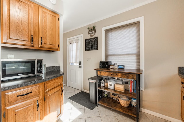 kitchen featuring light tile patterned floors and crown molding