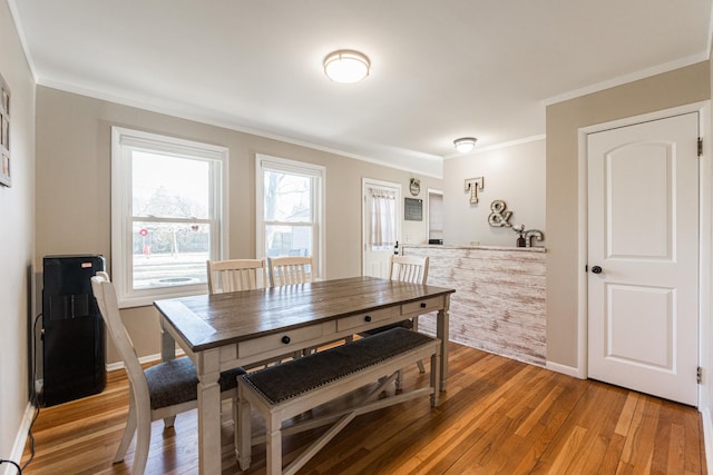 dining area with crown molding and hardwood / wood-style floors