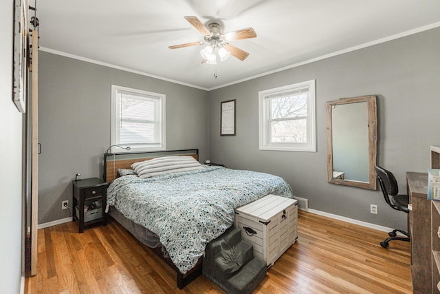 bedroom featuring crown molding, multiple windows, and light hardwood / wood-style flooring