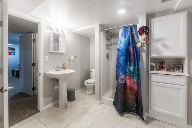 bathroom with tile patterned flooring, toilet, and walk in shower