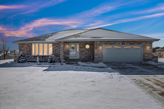 ranch-style home with a garage, driveway, and brick siding