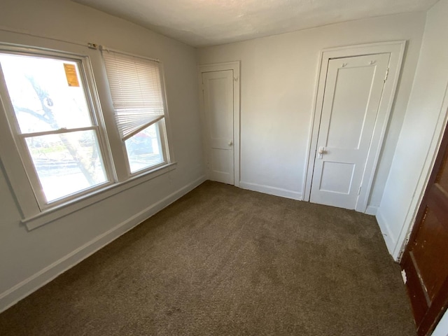 unfurnished bedroom with dark carpet