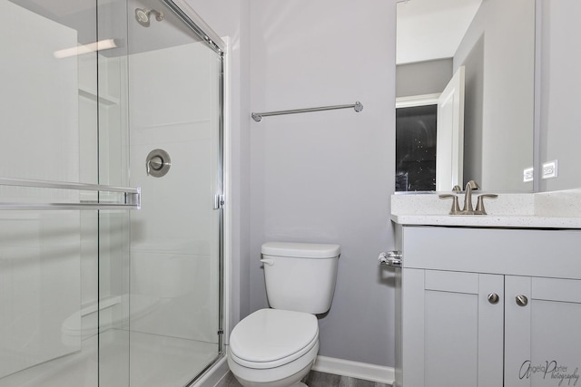 bathroom featuring vanity, an enclosed shower, and toilet