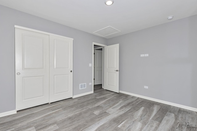 unfurnished bedroom with a closet and light wood-type flooring