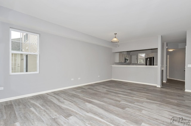 unfurnished living room featuring hardwood / wood-style floors and a wealth of natural light