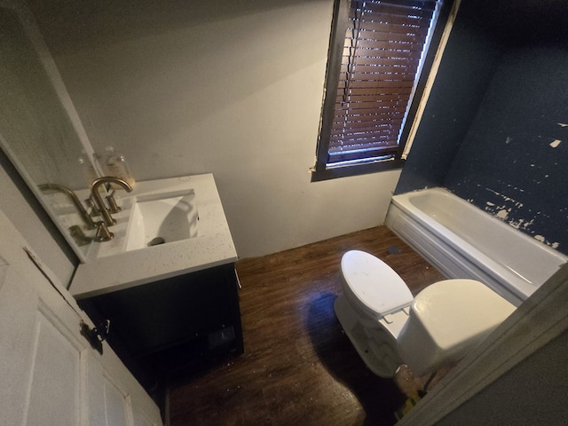 bathroom with vanity, wood-type flooring, a tub, and toilet