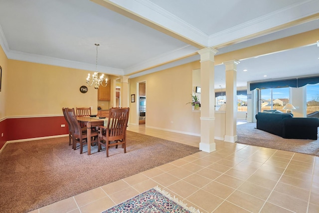 dining room with ornate columns, ornamental molding, light colored carpet, and an inviting chandelier