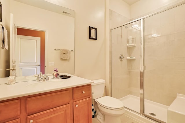 bathroom featuring an enclosed shower, vanity, and toilet