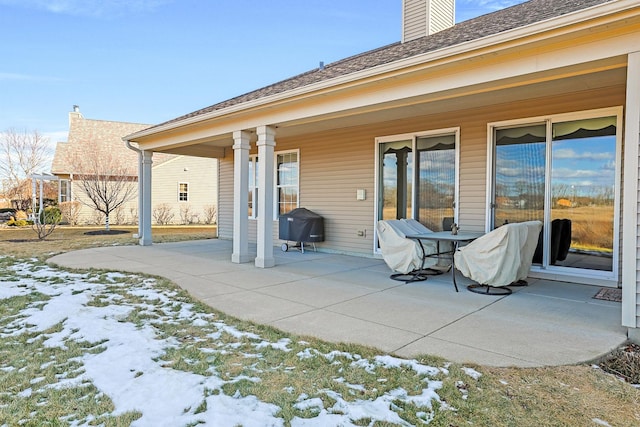 snow covered house featuring a patio area