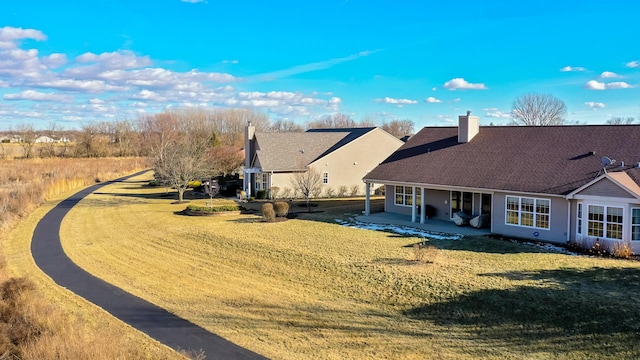 rear view of property with a patio and a lawn