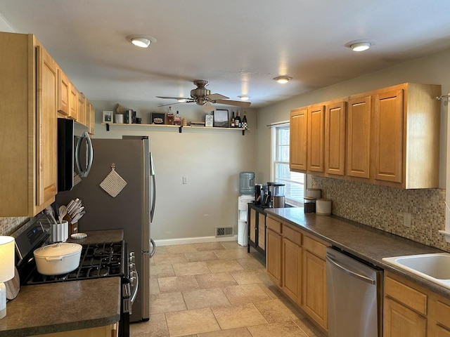 kitchen featuring ceiling fan, appliances with stainless steel finishes, sink, and backsplash