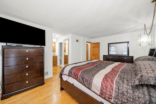 bedroom featuring ensuite bath and light wood-type flooring