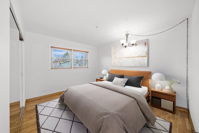 bedroom with an inviting chandelier, a closet, and light hardwood / wood-style flooring