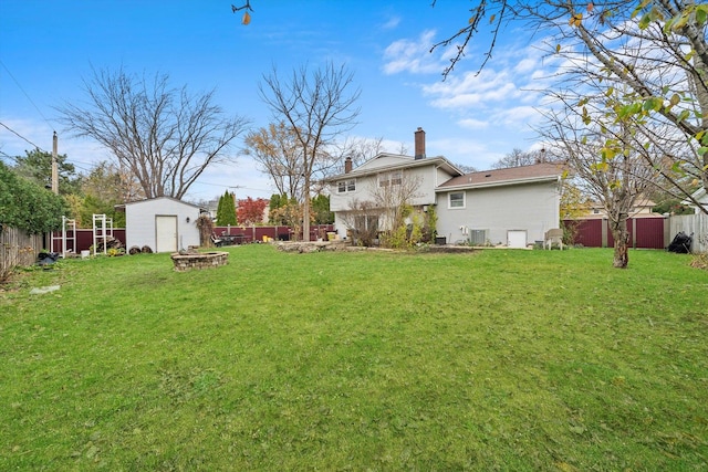 view of yard with a storage shed and an outdoor fire pit