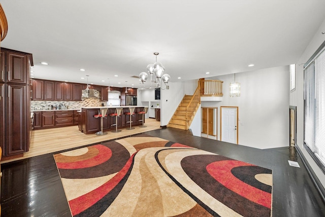 living room featuring an inviting chandelier, light hardwood / wood-style floors, and a wealth of natural light