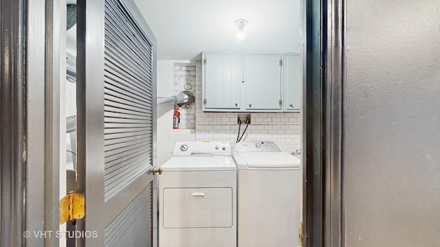 washroom featuring independent washer and dryer and cabinets