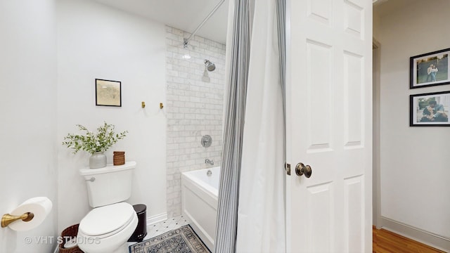 bathroom featuring toilet and tiled shower / bath combo