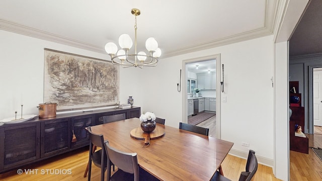 dining room with ornamental molding, light hardwood / wood-style flooring, and an inviting chandelier