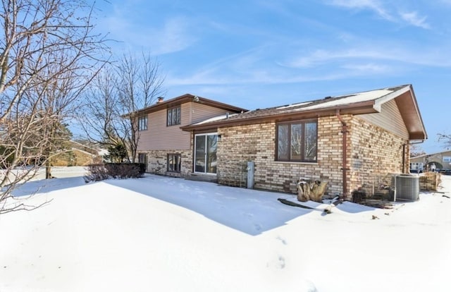 snow covered property featuring central AC unit