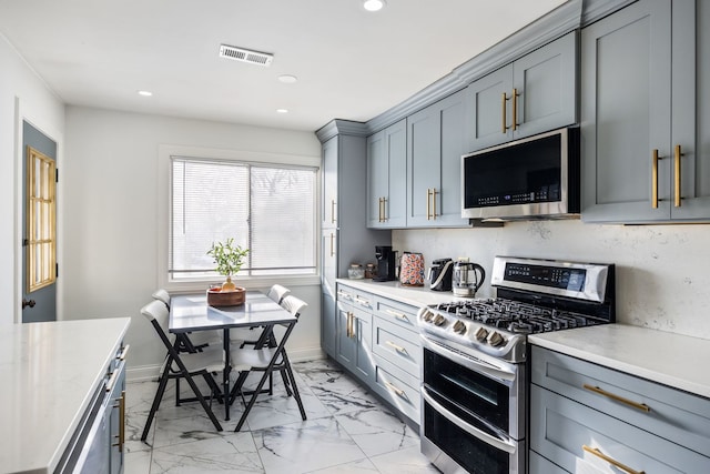 kitchen featuring stainless steel appliances, gray cabinetry, and decorative backsplash