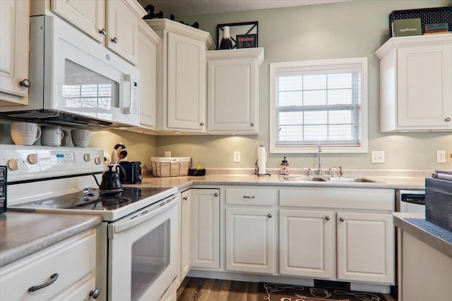 kitchen featuring white cabinetry, white appliances, dark hardwood / wood-style flooring, and sink