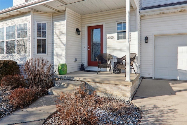 entrance to property featuring a garage and a porch