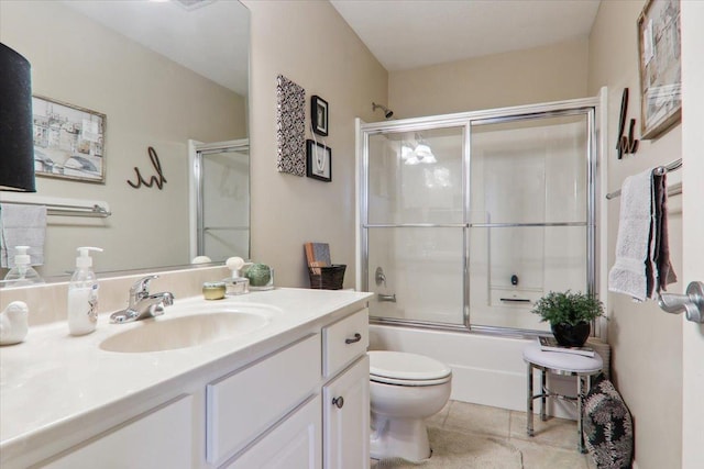 full bathroom with vanity, bath / shower combo with glass door, tile patterned floors, and toilet