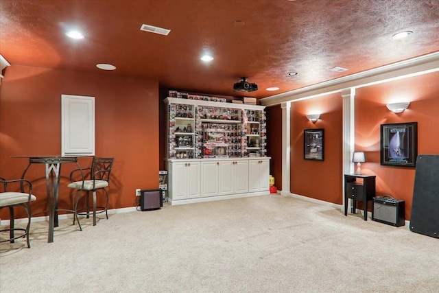 carpeted home theater with a textured ceiling