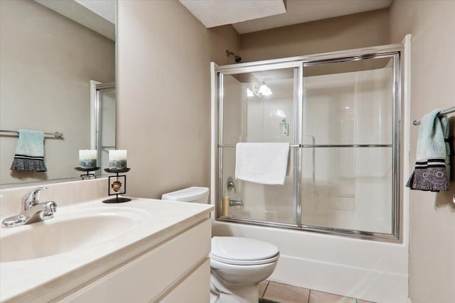 full bathroom featuring vanity, combined bath / shower with glass door, tile patterned floors, and toilet