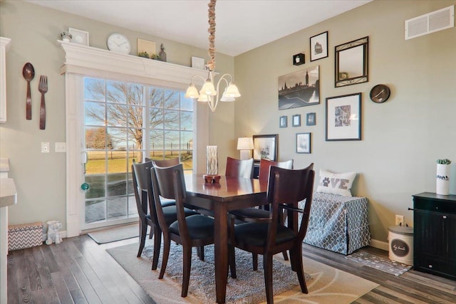 dining area featuring a notable chandelier and dark hardwood / wood-style floors