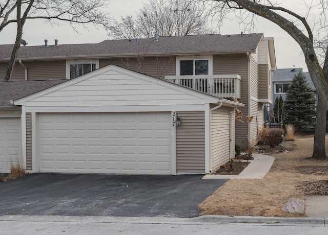 front facade featuring a garage and a balcony