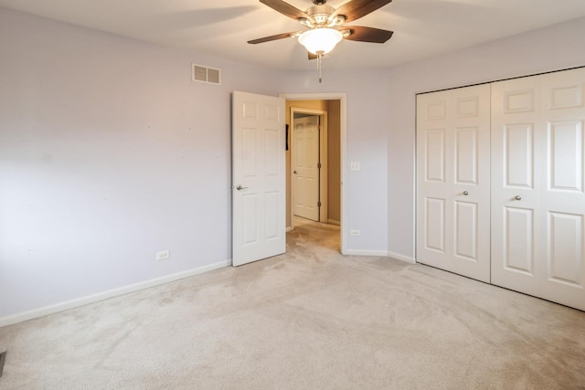 unfurnished bedroom with ceiling fan, light colored carpet, and a closet