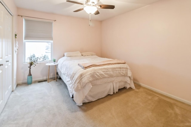 carpeted bedroom featuring ceiling fan and a closet